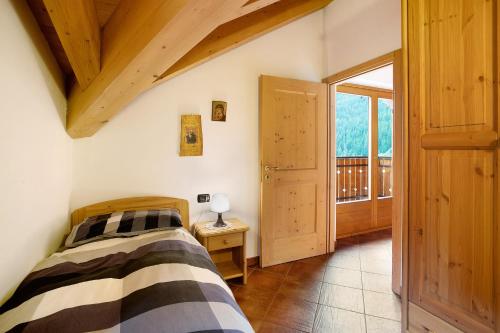 een slaapkamer met een bed en een houten plafond bij Casa Michela Trilocale Mansardato in Valfurva