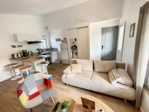 uma sala de estar com um sofá e uma cozinha em Les pénates du pastel - Jardin & Terrasse em Villefranche-de-Lauragais