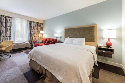 a hotel room with a large bed and a chair at Hampton Inn Columbus I-70E/Hamilton Road in Columbus
