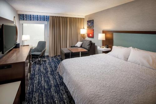 康梅克的住宿－康馬克/長島希爾頓恆庭酒店，酒店客房设有一张大床和一张沙发。
