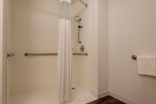 y baño con ducha con cortina blanca. en Hampton Inn Commerce, en Commerce