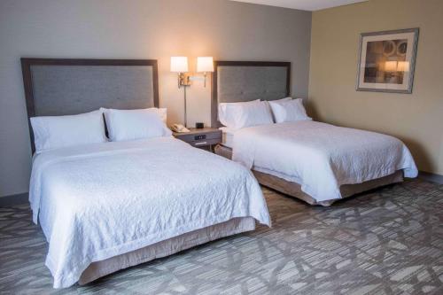 a hotel room with two beds with white sheets at Hampton Inn & Suites Tilton in Tilton