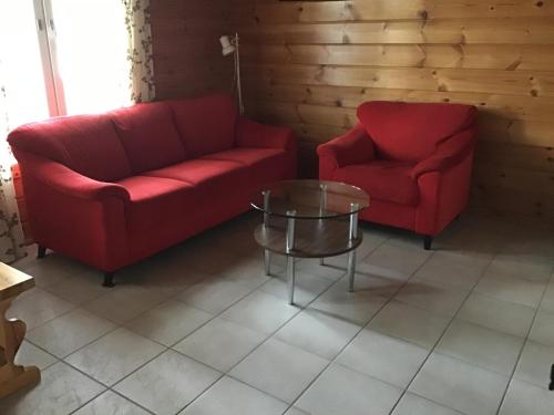 two red couches and a table in a room at Koli Country Club in Kolinkylä