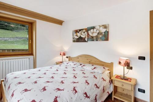 een slaapkamer met een bed, 2 lampen en een raam bij Casa Michela Bilocale in Valfurva