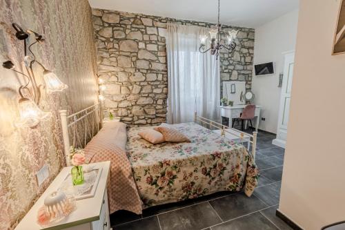 a bedroom with a bed and a stone wall at Agri Charme Tenuta Picilli in Albanella