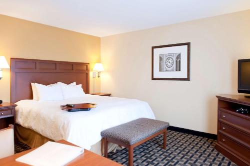 um quarto de hotel com uma cama e uma televisão em Hampton Inn & Suites Columbia at the University of Missouri em Columbia