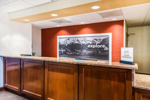 an office lobby with a large tv on the wall at Hampton Inn Clifton Park in Clifton Park