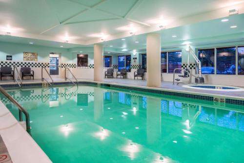 a pool in a hotel with chairs and tables at Hampton Inn Clifton Park in Clifton Park