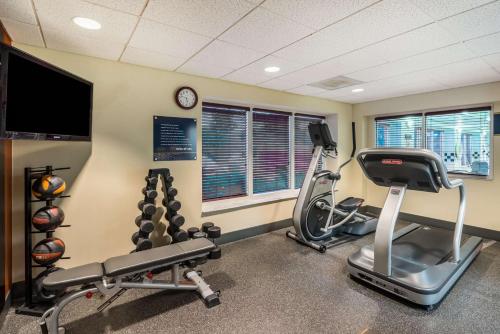 a gym with two tread machines and a flat screen tv at Hampton Inn Clifton Park in Clifton Park