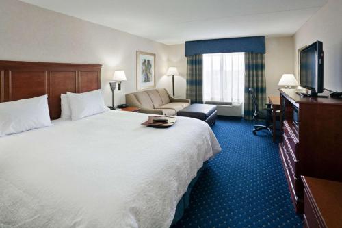 a hotel room with a large bed and a television at Hampton Inn Clifton Park in Clifton Park