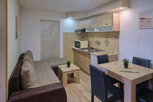 sala de estar y cocina con sofá y mesa en Apartmani Tvins en Soko Banja