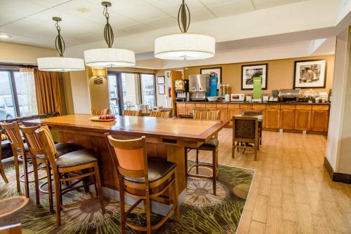 cocina y comedor con mesa de madera grande y sillas en Hampton Inn Caryville-I-75/Cove Lake-State Park, en Caryville