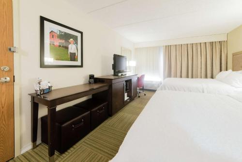 a hotel room with two beds and a desk with a television at Hampton Inn Caryville-I-75/Cove Lake-State Park in Caryville