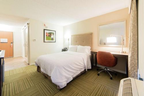 a hotel room with a bed and a desk and a chair at Hampton Inn Caryville-I-75/Cove Lake-State Park in Caryville