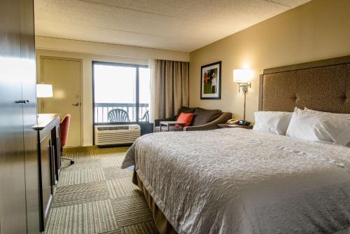 a hotel room with a large bed and a balcony at Hampton Inn Caryville-I-75/Cove Lake-State Park in Caryville