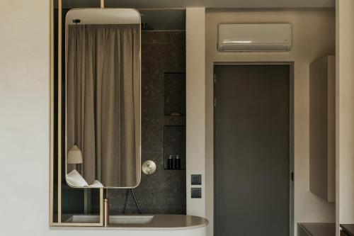 a bathroom with a mirror and a shower at AMÉNTE Mindful Stay in Plakias
