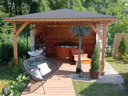 Chata Magnata في زاموسك: شرفة خشبية مع شرفة مع حوض استحمام ساخن