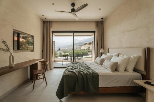 una camera d'albergo con un letto e una grande finestra di AMÉNTE Mindful Stay a Plakiás