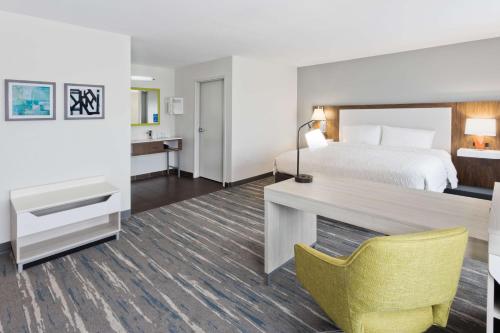 Habitación de hotel con cama y escritorio en Hampton Inn & Suites Phenix City- Columbus Area, en Phenix City