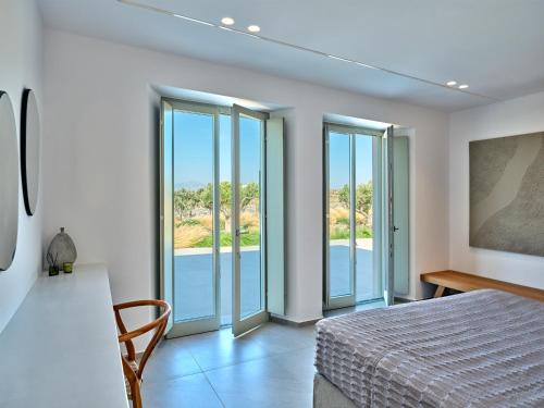 een slaapkamer met een bed en glazen schuifdeuren bij Villa Rojo in Santa Maria