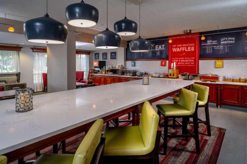a bar with green chairs and a counter in a restaurant at Hampton Inn Charleston Downtown in Charleston