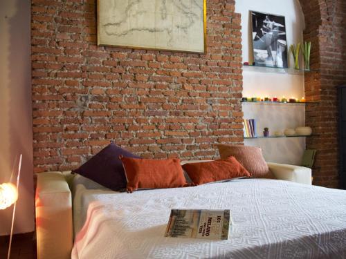 - une chambre avec un mur en briques et un lit dans l'établissement ALTIDO Cosy Apt for 2 near Train Station in Bohemian, à Milan