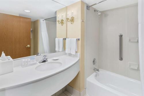 a bathroom with a sink and a tub and a shower at Hampton Inn Columbus-North in Columbus