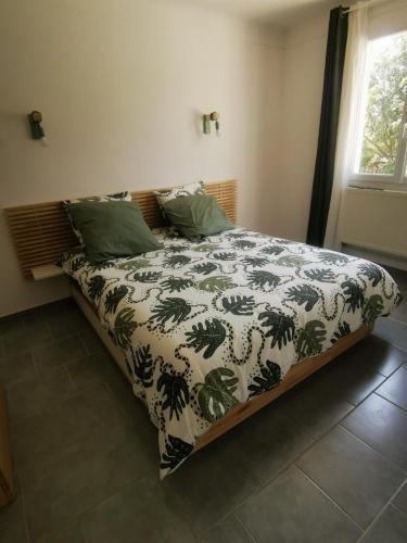 un lit avec une couette dessus dans une chambre dans l'établissement Le Fiacre entre chênes et oliviers dans le Luberon, à Cabrières-dʼAvignon