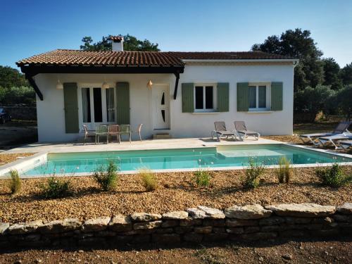 une villa avec piscine devant une maison dans l'établissement Le Fiacre entre chênes et oliviers dans le Luberon, à Cabrières-dʼAvignon