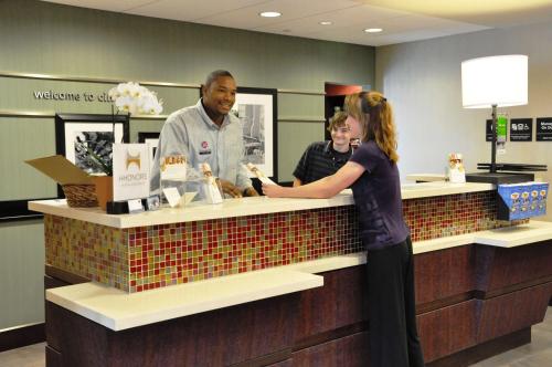 a woman is standing at a counter in a store at Hampton Inn & Suites Cincinnati / Uptown - University Area in Cincinnati