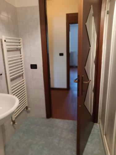 een badkamer met een toilet, een wastafel en een deur bij OASI DEL GARDA 5 in Monzambano