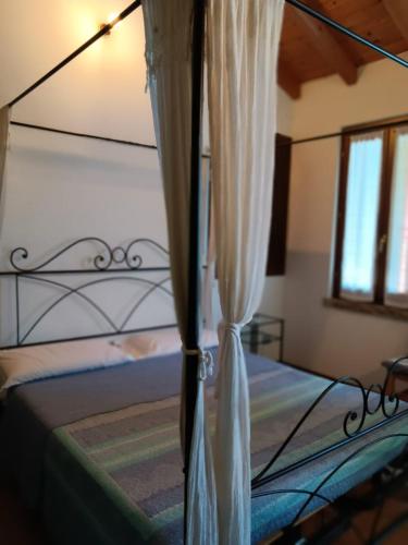 een slaapkamer met een bed met een metalen baldakijn bij OASI DEL GARDA 5 in Monzambano