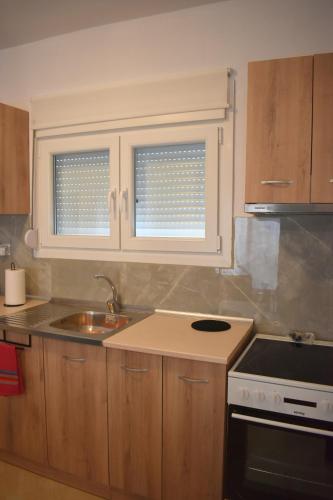 a kitchen with a sink and a stove and two windows at Charming House in Kástron