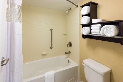 a bathroom with a tub and a toilet and towels at Hampton Inn Daytona Beach/Beachfront in Daytona Beach