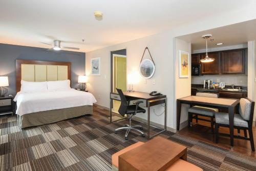a hotel room with a bed and a desk and a kitchen at Homewood Suites Cincinnati Airport South-Florence in Florence