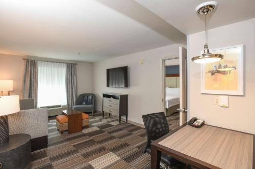 a living room with a room with a desk and a living room at Homewood Suites Cincinnati Airport South-Florence in Florence