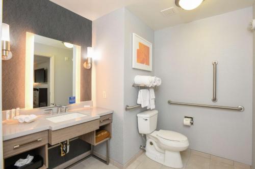 a bathroom with a toilet and a sink and a mirror at Homewood Suites Cincinnati Airport South-Florence in Florence