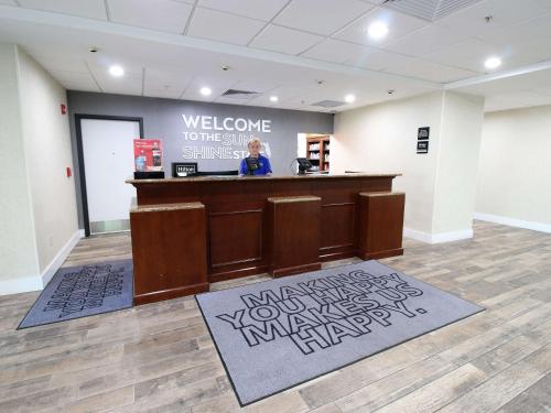 a woman standing at a counter in a lobby at Hampton Inn & Suites Palm Coast in Flagler Beach