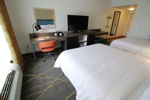 a hotel room with a bed and a desk with a computer at Hampton Inn & Suites Palm Coast in Flagler Beach