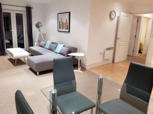 a living room with a couch and a glass table at Guest Homes - Propelair Apartment in Colchester