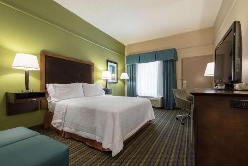 a hotel room with a bed and a flat screen tv at Hampton Inn Brooksville Dade City in Ridge Manor
