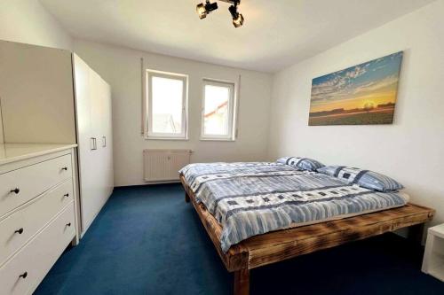 1 dormitorio con 1 cama y una pintura en la pared en Cozy-Livings / Parkplatz, TOP-Lage, Balkon, Küche, en Neu-Anspach