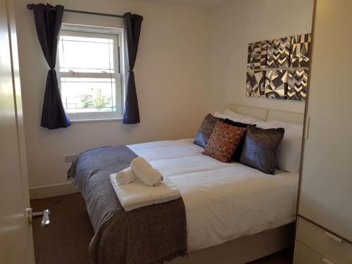 um quarto com uma cama grande e uma janela em Guest Homes - Propelair Apartment em Colchester