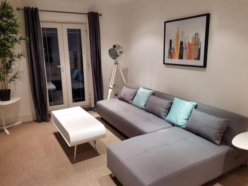 a living room with a couch and a table at Guest Homes - Propelair Apartment in Colchester