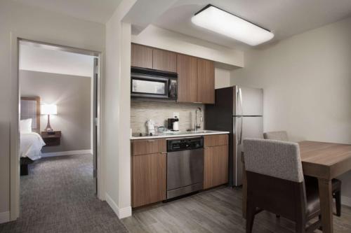 a small kitchen with a table and a refrigerator at Hampton Inn & Suites Dallas DFW Airport North Grapevine in Grapevine