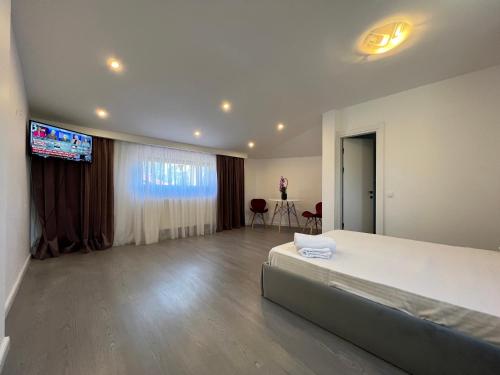 a bedroom with a large bed and a flat screen tv at Bucharest Center Villa in Bucharest