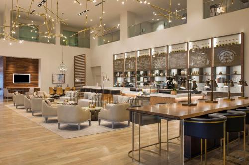 a restaurant with a bar with chairs and tables at DoubleTree by Hilton Hotel Dallas - Love Field in Dallas