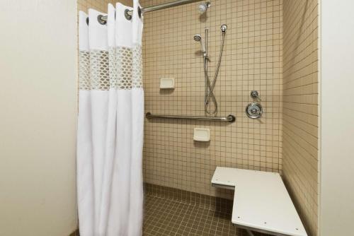 a bathroom with a shower with a white shower curtain at Hampton Inn Coventry-Warwick Area in Coventry