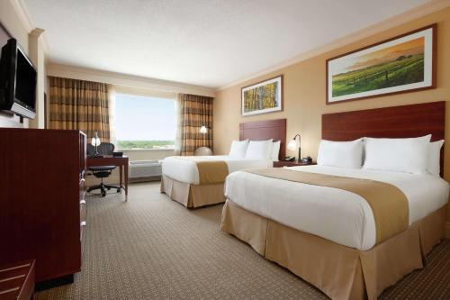 a hotel room with two beds and a desk at DoubleTree by Hilton Hotel Dallas - Love Field in Dallas
