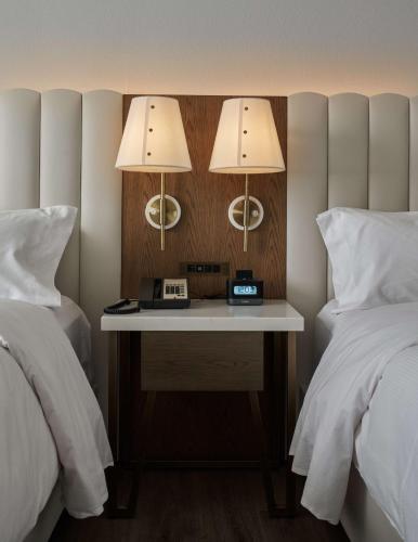 a bedroom with two beds and a table with two lamps at DoubleTree by Hilton Hotel Dallas - Love Field in Dallas